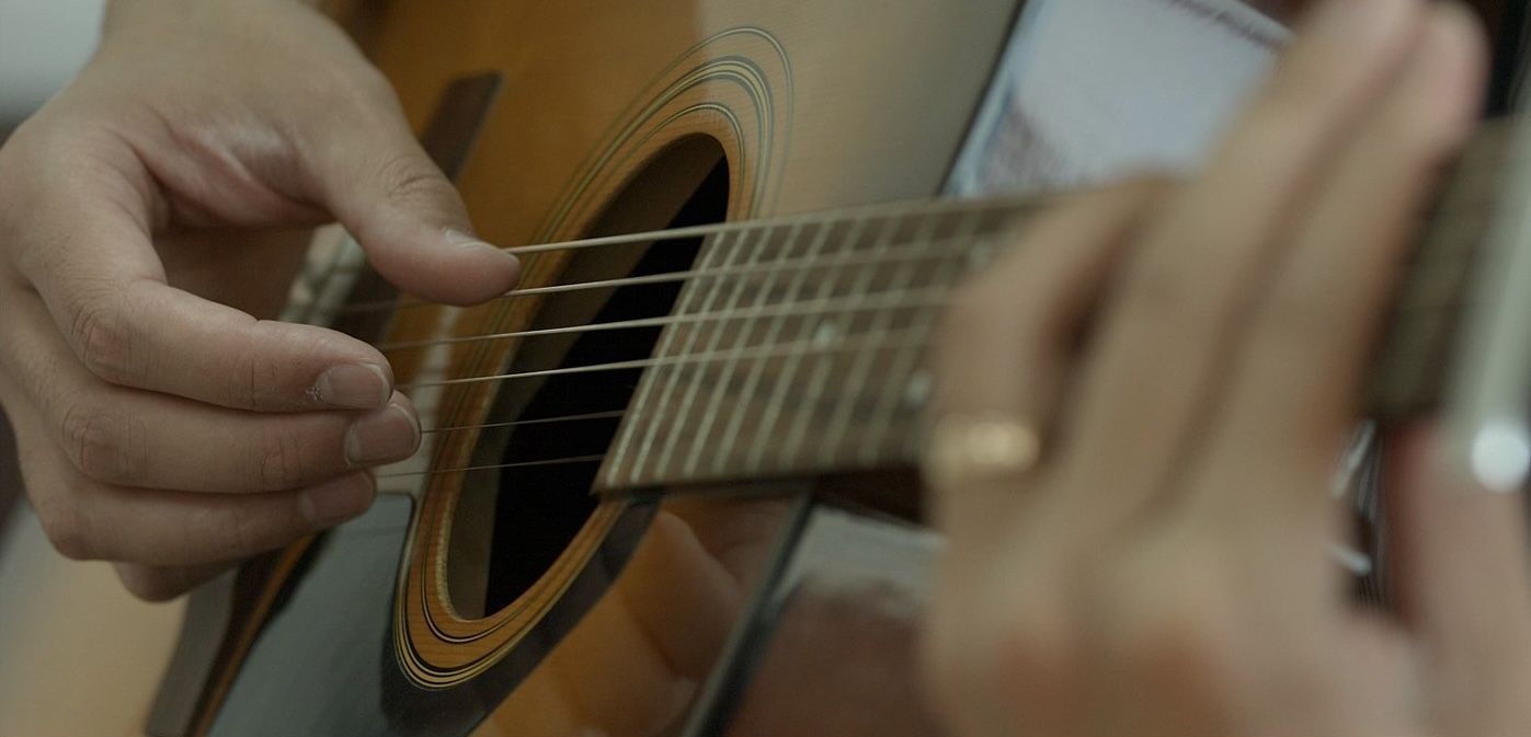 1600px-Close_up_of_an_acoustic_guitar_being_played.jpg