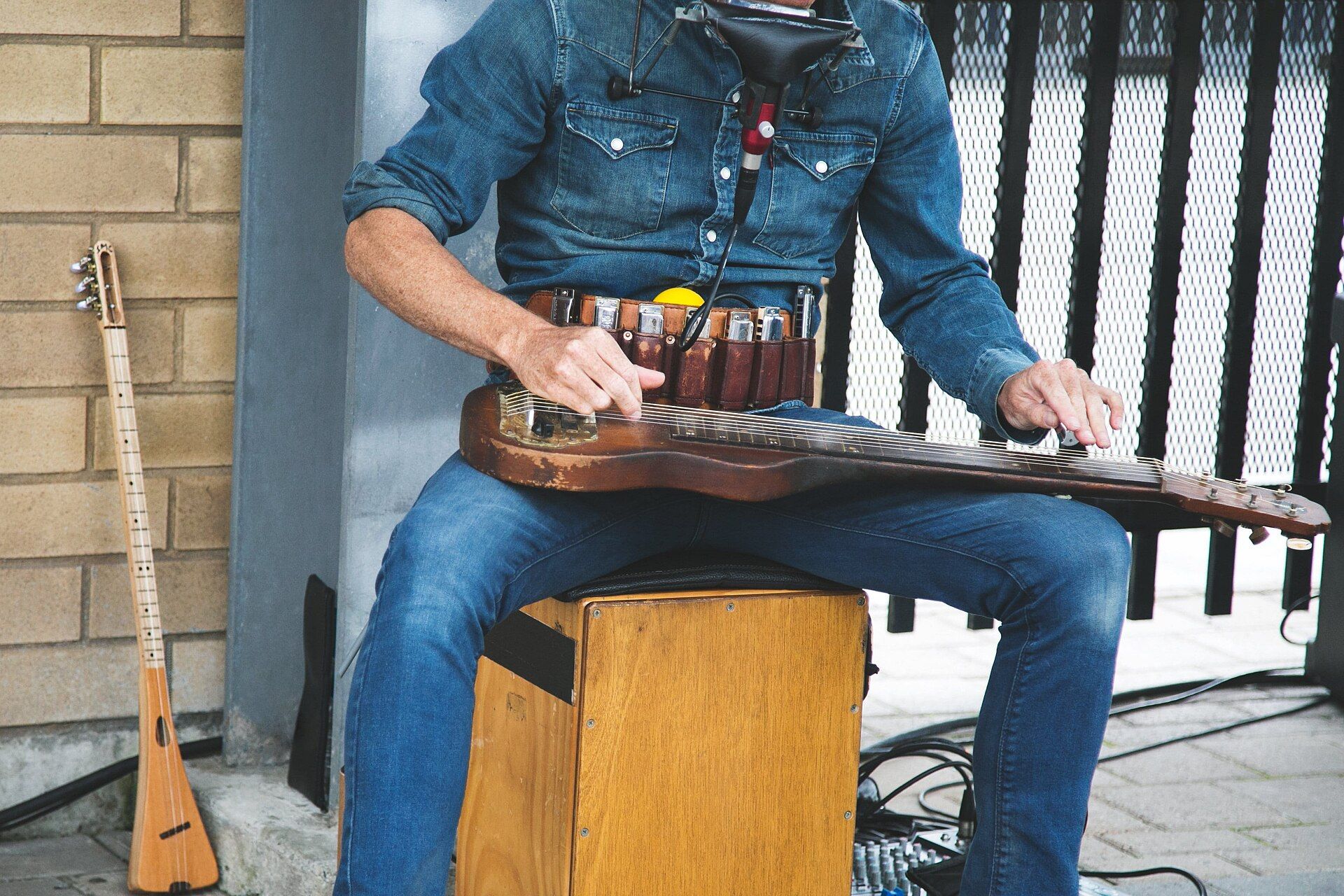 Street_performer_playing_a_lap_steel_guitar_and_harmonica_with_microphone,_sitting_on_a_cajon,_beside_a_3_string_instrument_(piqsels.com_en) (1).jpg